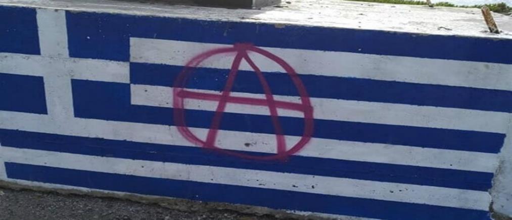 Εικόνες ντροπής: Έβαψαν με σπρέι στην ελληνική σημαία το σύμβολο της αναρχίας (εικόνες)
